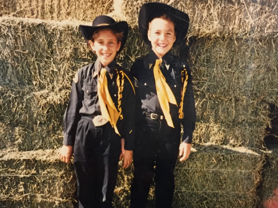 Two kids in cowboy hats on hay bales